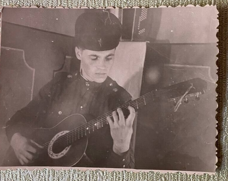  Guitar.    A young handsome guy plays the guitar.   Vintage 