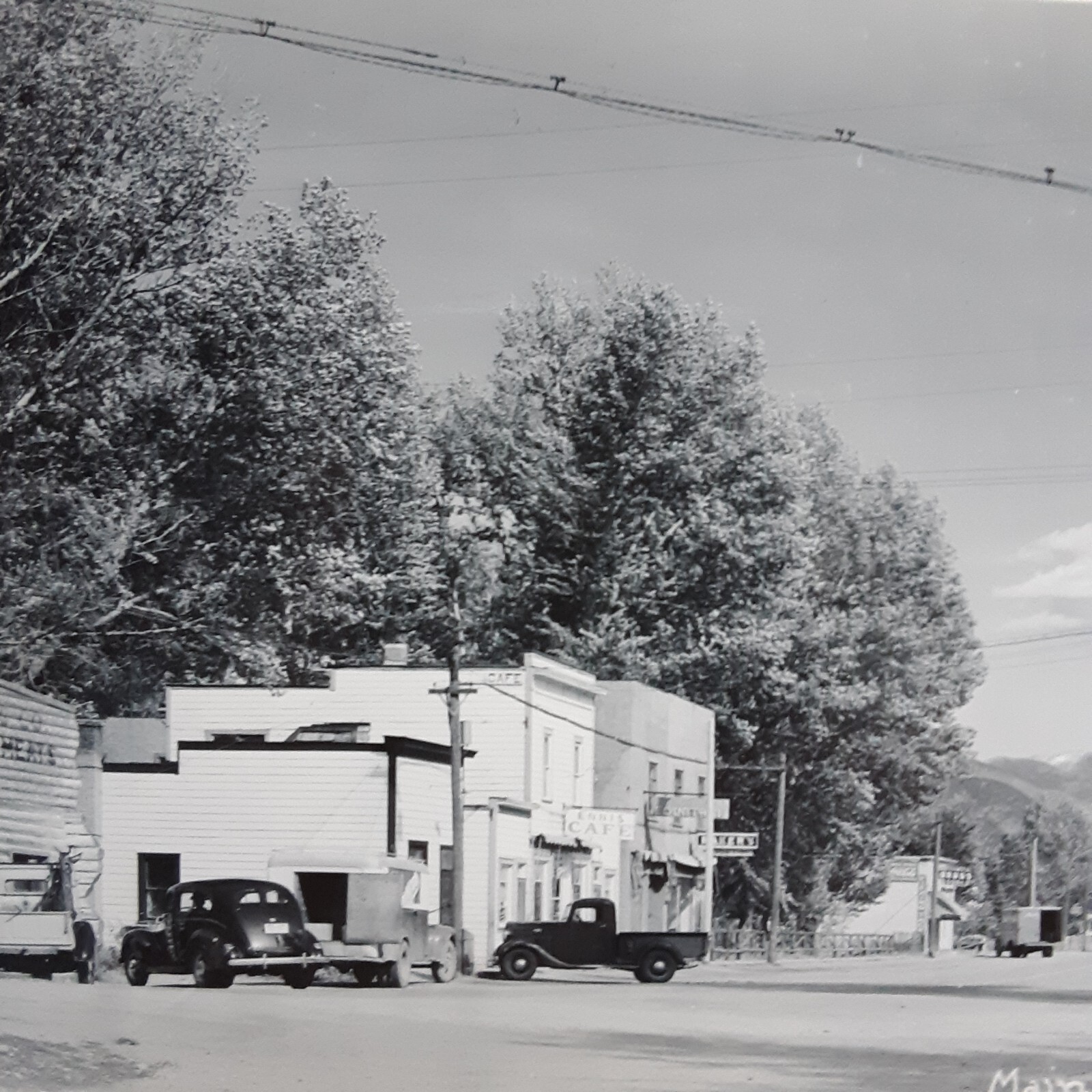 Real Photo Postcard RPPC Main Street Ennis, Montana. Banjo's Cafe, Theatre 1950s