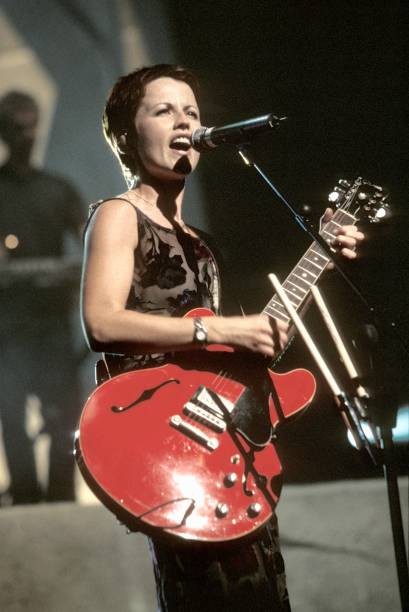 Singer Dolores O'Riordan is shown at a live concert appearance wit- Old Photo