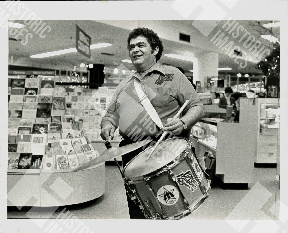 1983 A man is playing drums in a store