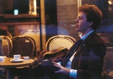 The Italian singer Umberto Tozzi smoking a cigarette sat at the ta- Old Photo picture